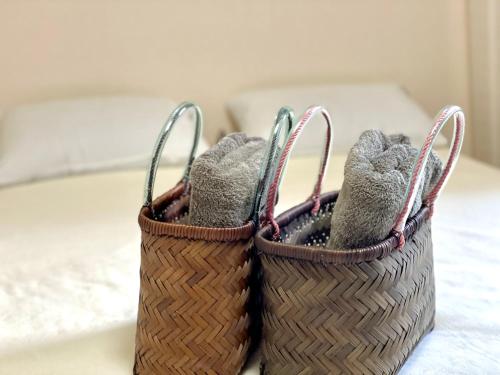 two baskets filled with socks sitting on a bed at ᛃ 眠りの癒 ᛃ Cozy Stay In The Heart of Beppu Apt 202 in Beppu