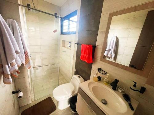 a bathroom with a toilet and a sink and a shower at Villa Nicolás Casa Campestre in Curití