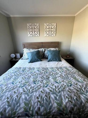 a bedroom with a large bed with blue pillows at Acogedor hogar en Rinconada de los Andes in Rinconada de los Andes