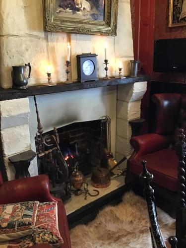 a living room with a fireplace with a clock and a chair at The Old Merchants House - The Highlands Room in Southampton