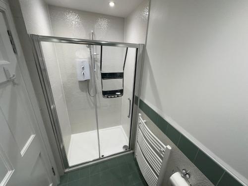 a shower with a glass door in a bathroom at One Bee in Edinburgh