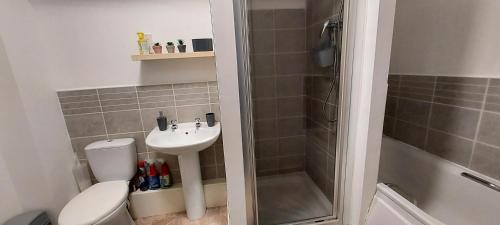 ein Bad mit einem WC, einem Waschbecken und einer Dusche in der Unterkunft Large 2 bed flat in Bolton in Farnworth