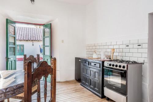 a kitchen with a stove and a table in it at Fundo Chincheros Lodge in Juliaca