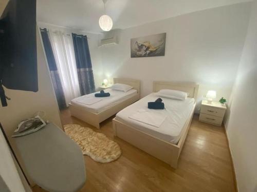 um pequeno quarto com 2 camas e um sofá em Cozy Apartment em Tirana