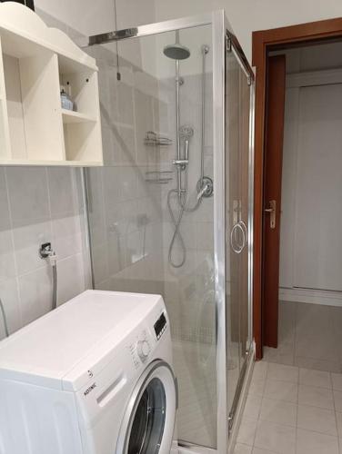 een wasmachine in een badkamer met een douche bij La casetta a Gorgonzola in Gorgonzola