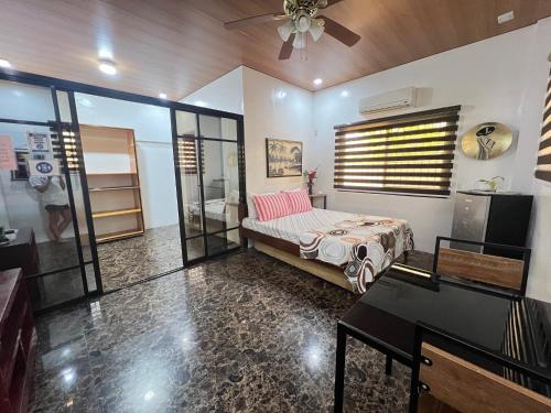 a bedroom with a bed and a table and a piano at Villa Lourdes in Alaminos