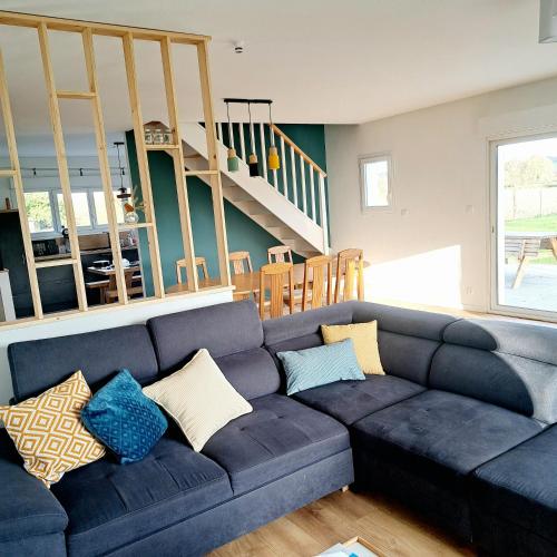 un salon avec un canapé bleu avec des oreillers dans l'établissement La maison au bout du chemin, à Poey-dʼOloron