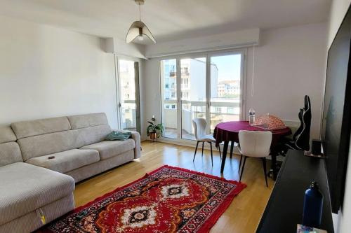 uma sala de estar com um sofá e uma mesa em Riverside Retreat with balcony & parking em Courbevoie