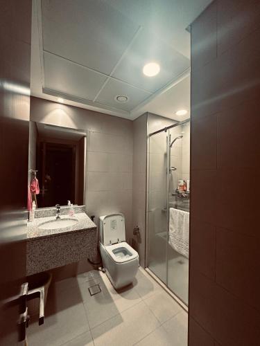 a bathroom with a toilet and a sink and a shower at R F Homes Shared Apartment in Dubai in Dubai