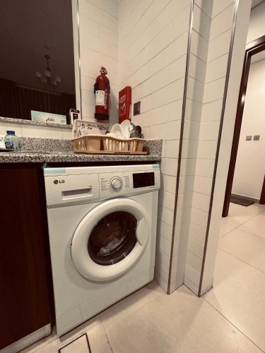 a white washing machine in a kitchen next to a counter at R F Homes Shared Apartment in Dubai in Dubai