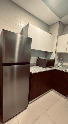 a kitchen with a stainless steel refrigerator and a microwave at R F Homes Shared Apartment in Dubai in Dubai