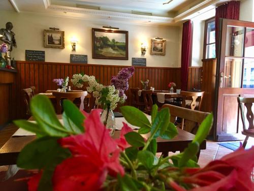 une salle à manger avec des tables et des fleurs dans un restaurant dans l'établissement Hotel Auberge Rustique, à Beaufort