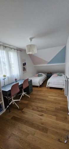 une chambre avec deux lits, une table et des chaises dans l'établissement Maison cosy, RER direct PARIS et STADE DE FRANCE, proche ORLY, à Brunoy