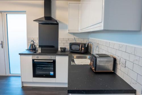 a kitchen with a stove and a toaster on a counter at The Beach House in Edinburgh