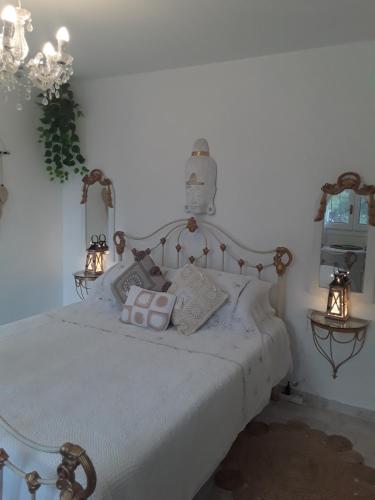 Un dormitorio con una cama blanca con almohadas. en Apartment CALISTROS BENITACHELL MINIMUM STAY ONE NIGHT, en Benitachell