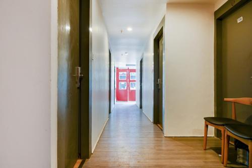 um corredor com uma porta vermelha num edifício em Townhouse Hi5 Aditya International em Bhubaneshwar