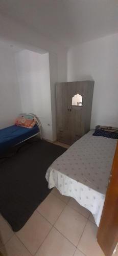 a small room with a bed and a small window at Villa in Durrës