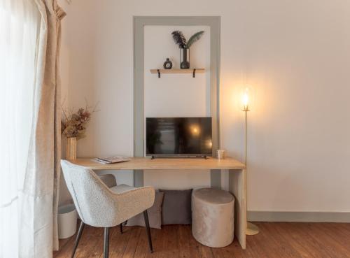 Cette chambre comprend un bureau avec une télévision et une chaise. dans l'établissement Charmante suite aux Chartrons, à Bordeaux