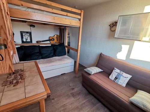 - un salon avec un canapé et des lits superposés dans l'établissement Sybelles - Corbier - Studio Skis aux pieds, à Villarembert