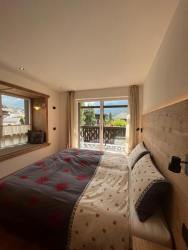 Un dormitorio con una cama grande y una ventana. en Ciasa Valiares, en San Vigilio Di Marebbe