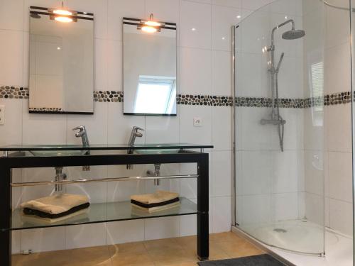 een badkamer met 2 wastafels en een douche bij Charmante maison moderne entre terre et mer in Coray