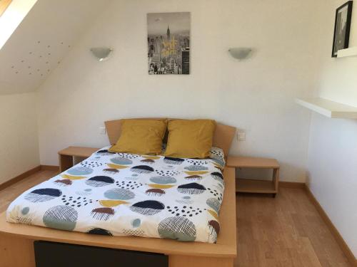 een slaapkamer met een bed met een kleurrijk dekbed bij Charmante maison moderne entre terre et mer in Coray