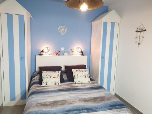 1 dormitorio con 1 cama con rayas azules y blancas en CARPE DIEM, en Friaucourt
