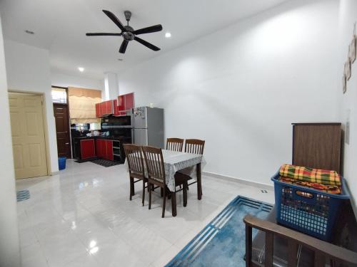 a kitchen and dining room with a table and chairs at Indah Damai Homestay in Kepala Batas