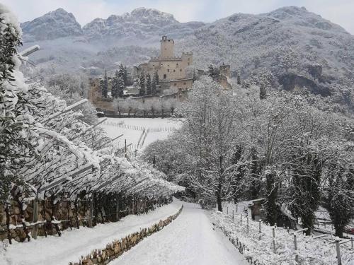 a snow covered road with a castle in the background at Appartamento CS in Sabbionara