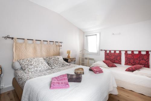 2 camas en un dormitorio con almohadas rosas. en Gite Les Aiguillans, en Mérindol-les-Oliviers