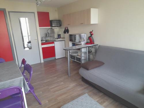un petit salon avec un canapé et une cuisine dans l'établissement A 3 minutes à pied de la plage, au Grau-du-Roi