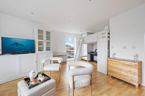 a living room with a tv and a table and chairs at Stylish Central London Bolthole in London