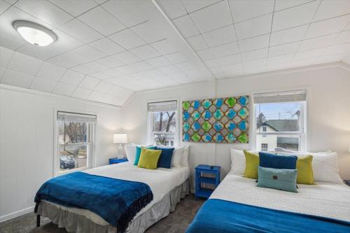 2 camas en una habitación con 2 ventanas en White House Bungalow, en Bay City