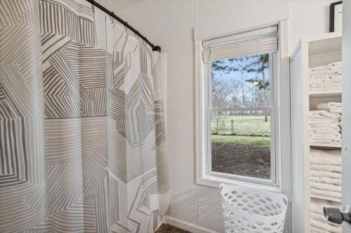 a bathroom with a shower with a toilet and a window at White House Bungalow in Bay City