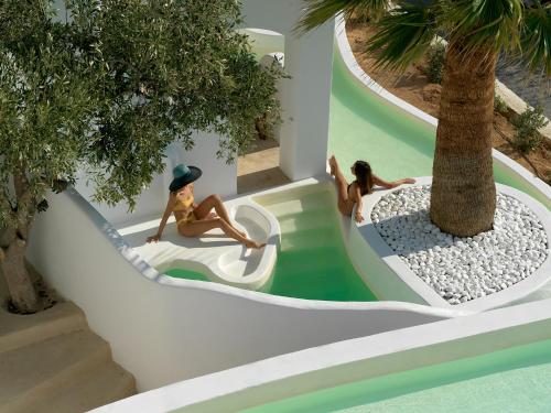 twee meisjes op een waterglijbaan in een resort bij Aloni Hotel & Suites in Piso Livadi