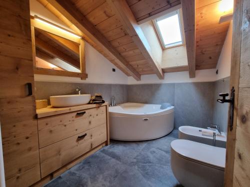 e bagno con vasca, servizi igienici e lavandino. di Casa Panoràma in the heart of the Dolomites, Moena a Moena