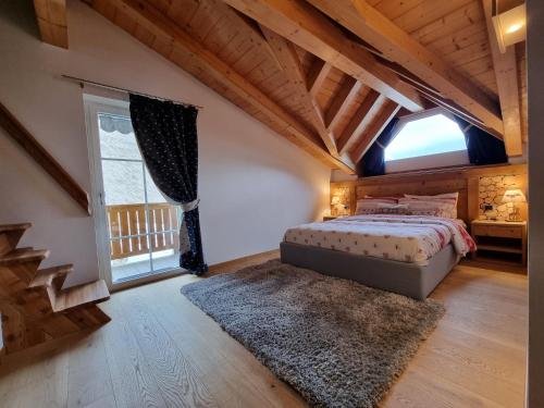 una camera con un letto e una grande finestra di Casa Panoràma in the heart of the Dolomites, Moena a Moena