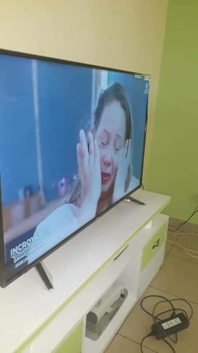 a television with a picture of a woman on it at Village des Aviateurs in Nkolnda