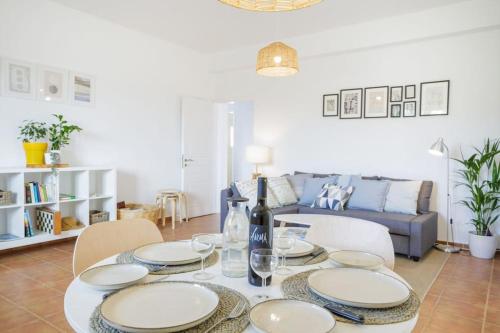a dining room table with plates and wine glasses at Alethea's Sea View Apartment in Kalamaki