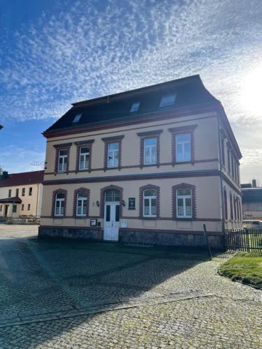 a large white building with a black roof at Hotel zur Schlossmühle in Borna