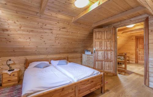 1 dormitorio con 1 cama en una cabaña de madera en Kuća za odmor Balenović, en Gospić