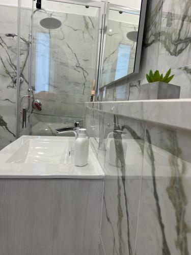 a bathroom with a white sink and a mirror at La Corte del Moro in Pachino