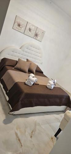 a bedroom with a large bed in a white room at La Corte del Moro in Pachino