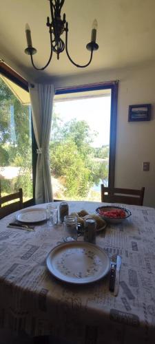 a table with a plate on it with a window at El paraíso de Quillon in Quillón