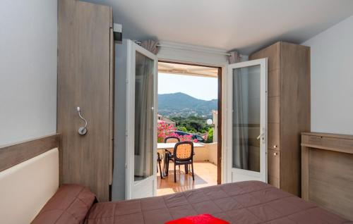 a bedroom with a bed and a view of a balcony at Hôtel et Résidence Ta Kladia - Omigna in Cargèse