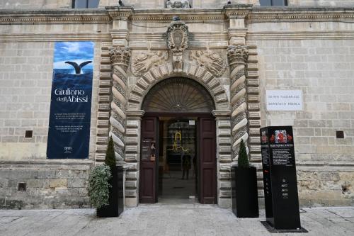 a door to a building with a sign in front of it at Profumi di Primavera Luxury Rooms & Suite in Matera