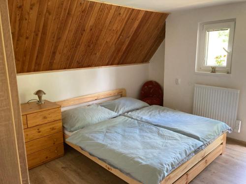 - une chambre avec un lit et un plafond en bois dans l'établissement Chata Tereza, à Merklín