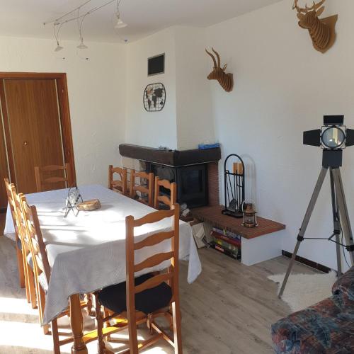 une salle à manger avec une table et une cheminée dans l'établissement Maison vosgienne proche de la Bresse et Gerardmer, à Basse-sur-le-Rupt