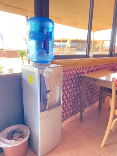 a drink machine with a blue water pitcher on top of it at Rum Elegant luxury camp in Wadi Rum
