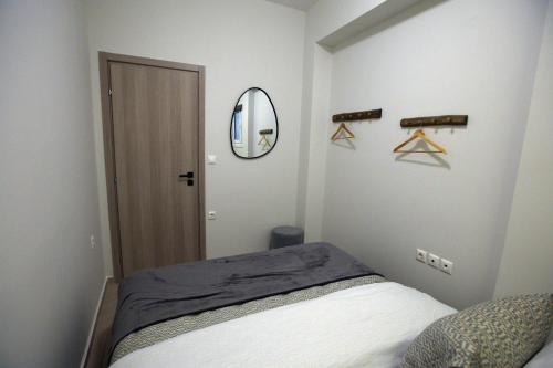 a bedroom with a bed and a mirror and hangers at EVNEA in Nafplio